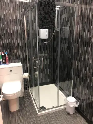 a shower with a glass door in a bathroom at Baxter Holiday Apartments in Blackpool