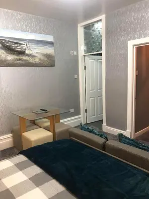 a living room with a table and a couch at Baxter Holiday Apartments in Blackpool