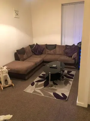 a living room with a couch and a table at Baxter Holiday Apartments in Blackpool