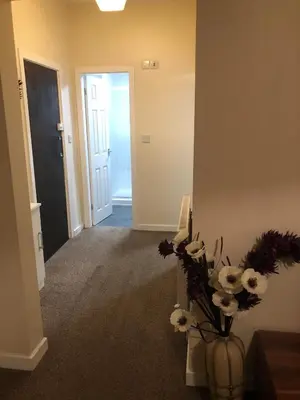 a hallway with a vase with flowers in it at Baxter Holiday Apartments in Blackpool