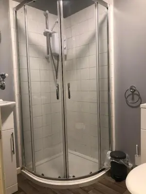 a shower with a glass door in a bathroom at Baxter Holiday Apartments in Blackpool