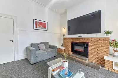 a living room with a couch and a fireplace at Pleasure Holiday Apartments in Blackpool