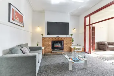 a living room with a couch and a fireplace at Pleasure Holiday Apartments in Blackpool