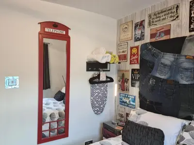 a room with a mirror and a bed with jeans on the wall at The Arthington in Blackpool