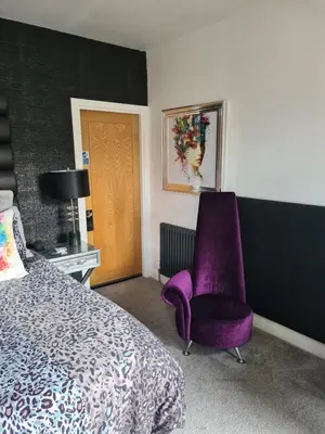 a bedroom with a purple chair and a bed at The Arthington in Blackpool