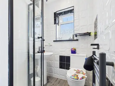a white bathroom with a toilet and a sink at The Arthington in Blackpool