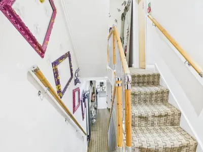 a staircase in a home with colorful paintings on the walls at The Arthington in Blackpool