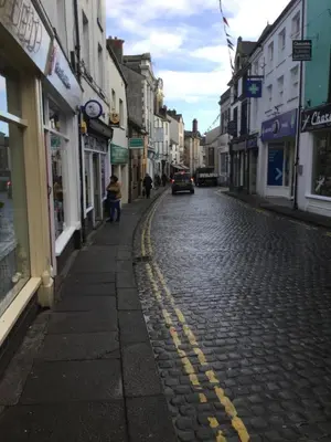 a cobblestone street with a car driving down the street at The Warehouse in Ulverston