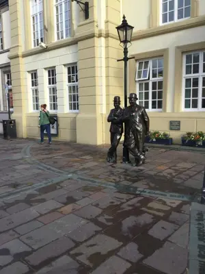 two statues of people standing in front of a building at The Warehouse in Ulverston