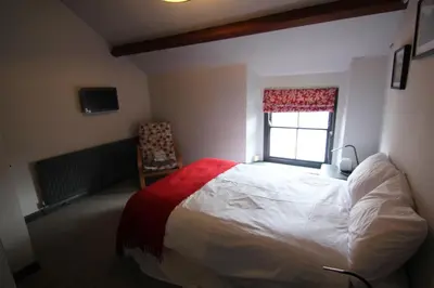 a bedroom with a large bed and a window at The Warehouse in Ulverston