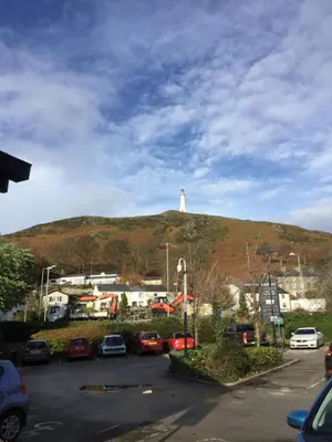 a white lighthouse on top of a hill with cars at The Warehouse in Ulverston
