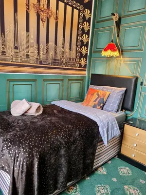 a bedroom with a bed with a blue wall at The Mercury in Blackpool