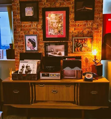 a table with a radio and pictures on a brick wall at The Mercury in Blackpool