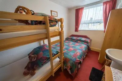 a bedroom with two bunk beds and a teddy bear at Lyndale Holiday Flats in Blackpool