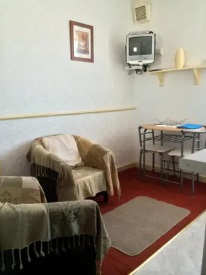 a living room with a tv and a chair and a table at Lyndale Holiday Flats in Blackpool