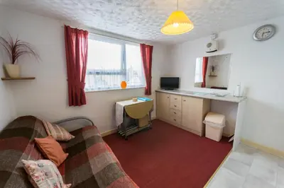 a room with a bed and a desk with a computer at Lyndale Holiday Flats in Blackpool