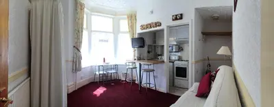 a kitchen with a table and chairs in a room at Lyndale Holiday Flats in Blackpool
