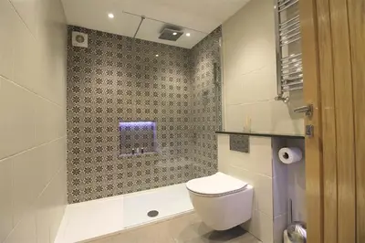 a bathroom with a toilet and a bath tub at The Old Roller Shed in Cartmel