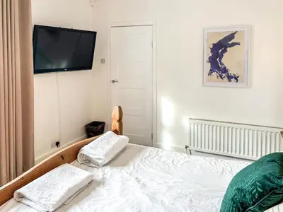 a bedroom with a bed and a flat screen tv at Highcross in Poulton le Fylde