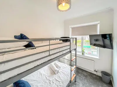 a bedroom with two bunk beds and a flat screen tv at Highcross in Poulton le Fylde