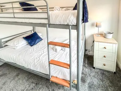 a bunk bed room with two bunk beds and a night stand at Highcross in Poulton le Fylde