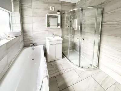 a bathroom with a bath tub and a shower at Highcross in Poulton le Fylde