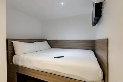 a bed with a remote control sitting on top of it at The Podworks Hotel in Liverpool