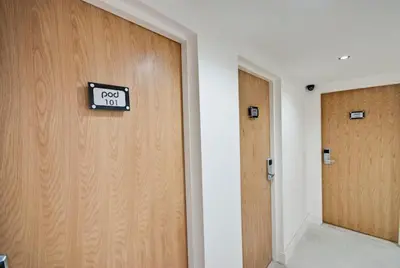 a door with a sign on it next to two doors at The Podworks Hotel in Liverpool