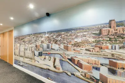 a large mural of a city on a wall at The Podworks Hotel in Liverpool
