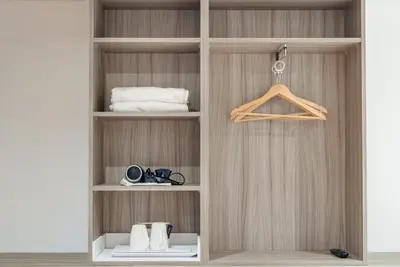 a wooden pantry door with a shelf and towels at The Podworks Hotel in Liverpool