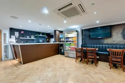 a bar in a restaurant with chairs and a counter at The Podworks Hotel in Liverpool