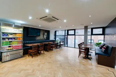 a restaurant with a bar and tables and chairs at The Podworks Hotel in Liverpool