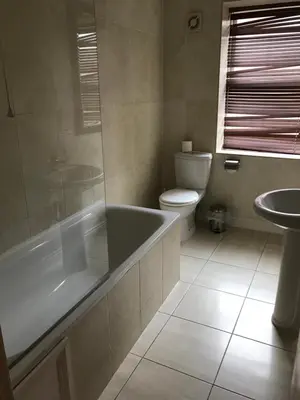 a bathroom with a tub and a toilet and a sink at Sheil Suites in Liverpool