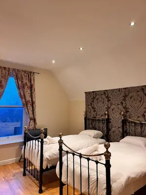 two twin beds in a bedroom with a window at Sheil Suites in Liverpool