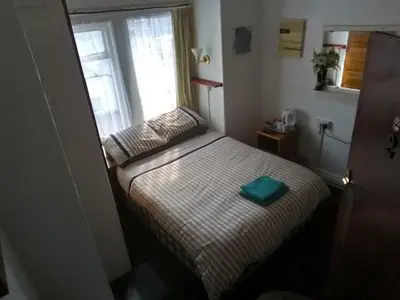 a small bedroom with a bed and a window at MyRoomz Golden Strand Hotel in Blackpool