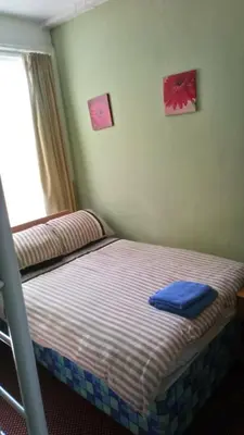 a bedroom with two beds and a window at MyRoomz Golden Strand Hotel in Blackpool