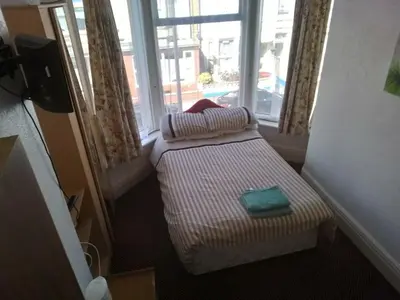 a small bed in a room with a window at MyRoomz Golden Strand Hotel in Blackpool