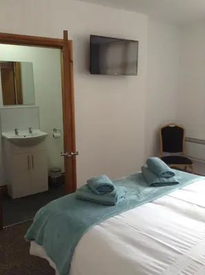 a bedroom with a bed with towels on it at The Bear On The Square in Millom