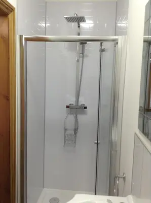 a shower with a glass door in a bathroom at The Bear On The Square in Millom