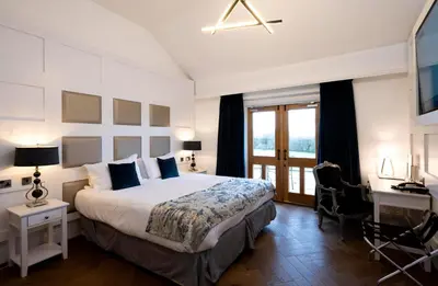 a bedroom with a large bed and a desk and a bed at Stanley House Hotel & Spa in Blackburn