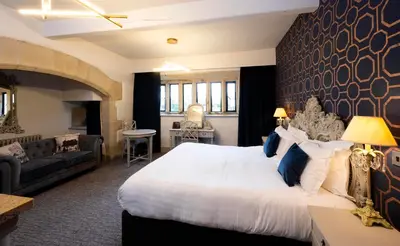 a hotel room with a large bed and a couch at Stanley House Hotel & Spa in Blackburn