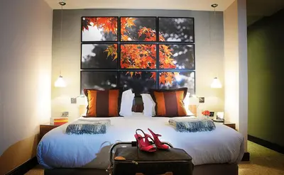 a bedroom with a bed with two red shoes on it at Stanley House Hotel & Spa in Blackburn