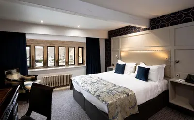 a hotel room with a large bed and a desk at Stanley House Hotel & Spa in Blackburn