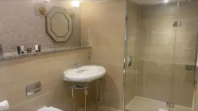 a bathroom with a sink and a shower at Stanley House Hotel & Spa in Blackburn