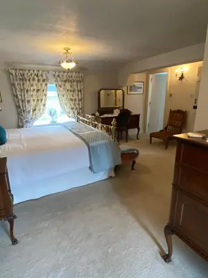 a bedroom with a large white bed and a piano at Chapel Cottage Clitheroe Road in Waddington