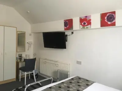 a bedroom with a bed and a tv on the wall at The Address in Blackpool