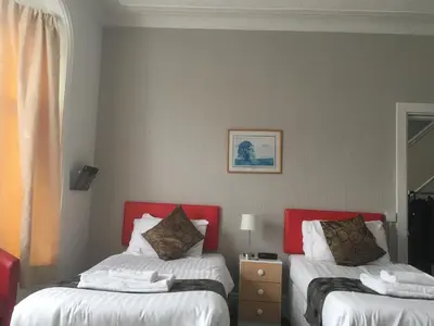 a bedroom with two beds with red headboards at The Address in Blackpool