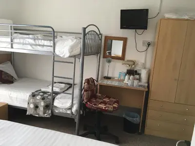 a bedroom with a bunk bed and a desk with a chair at The Address in Blackpool