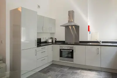 a kitchen with white cabinets and a stove at The Castle Collection 14 Cook Street in Liverpool