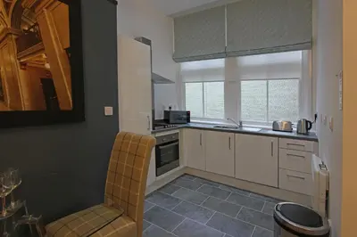 a kitchen with white cabinets and a sink and a window at The Castle Collection 14 Cook Street in Liverpool
